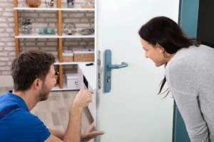 A woman receives assistance from a man in a blue t-shirt to unlock her door, showcasing a helpful and supportive gesture